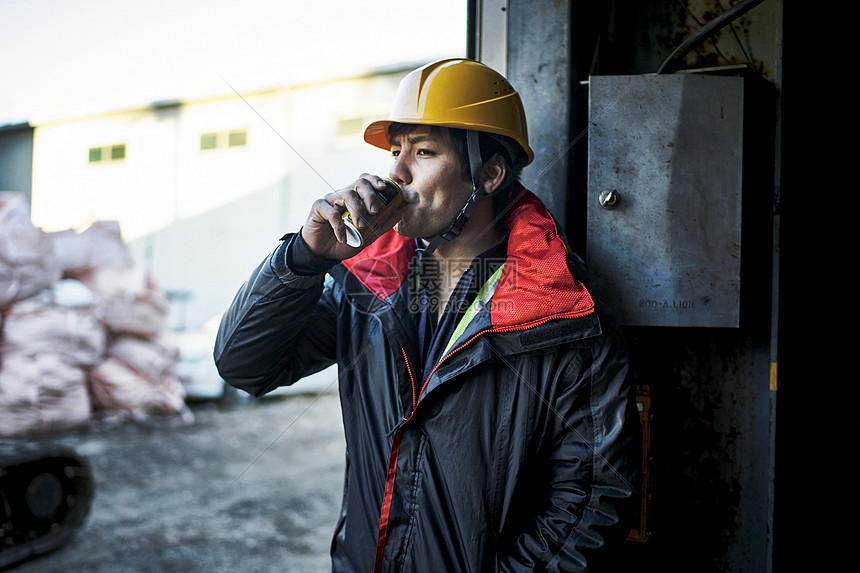 高清照片下载,该高清照片标题为建筑工地工人男人喝罐装饮料,编号