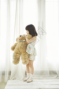 抱着泰迪熊布娃娃的女孩图片