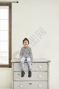 坐在鞋柜上的小男孩图片