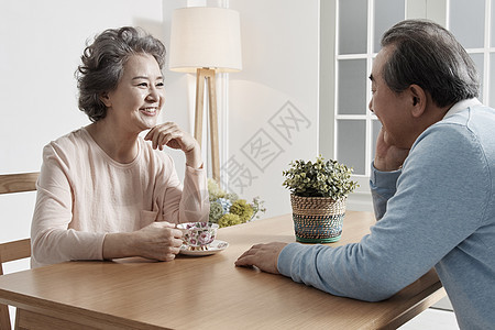 餐桌上喝茶聊天开心的夫妇图片