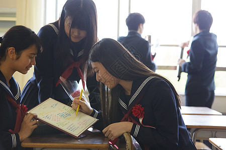 在纪念簿上写留言的女孩们图片