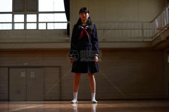 站在学校体育馆场地里的毕业生女孩图片