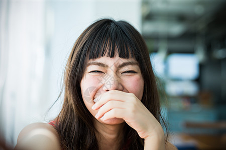 捂嘴大笑的年轻女性图片