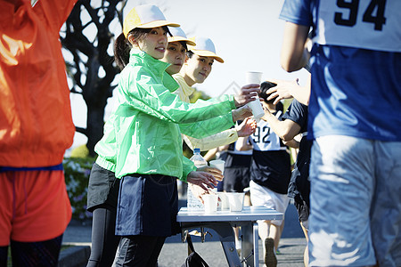 女人在马拉松比赛供水站送水背景图片