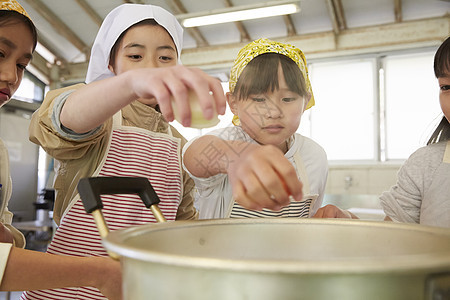 将食材放入锅中的女孩们图片