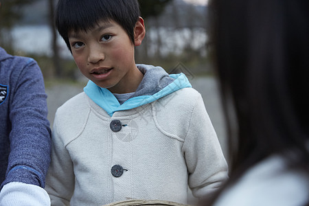 户外快乐的小学生拿木柴篝火背景图片