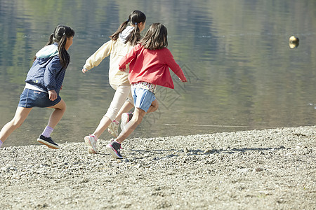 假期户外活动小学生在河边奔跑图片