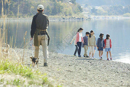 假期户外活动小学生和老师在河边散步图片