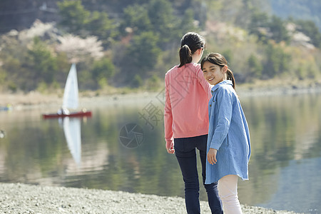 湖边露营在湖边散步的母女背景