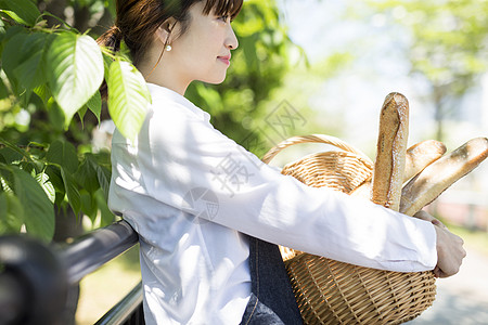 抱着一筐新鲜法棍的女孩高清图片