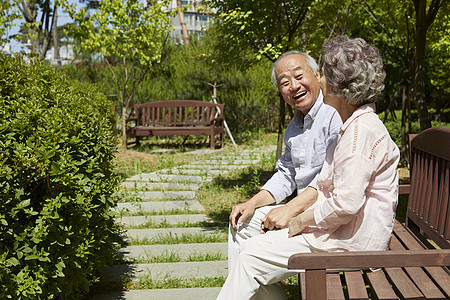 坐在公园长凳上的老年夫妇图片