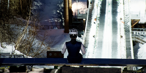 夜晚滑雪场大跳台训练的运动员背景图片