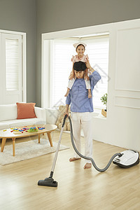 女儿和爸爸在用吸尘器做家务图片