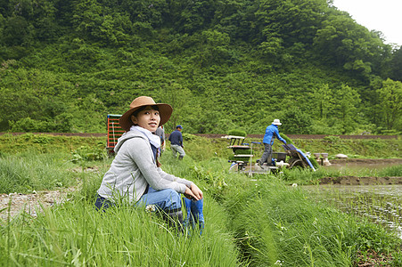 种植水稻后在田里休息的年轻农民图片