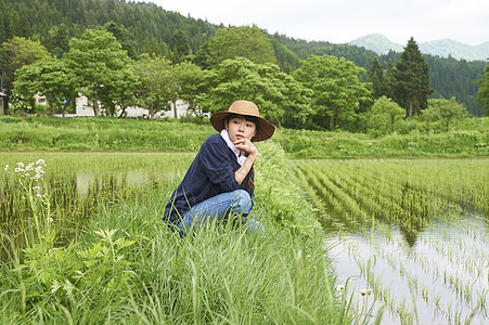 种植水稻后在田里休息的年轻农民图片