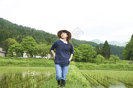 种植水稻后在田里休息的年轻农民图片