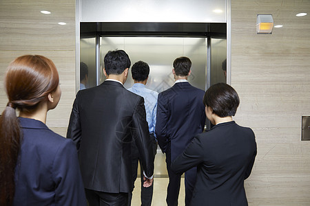 乘坐电梯的商务人士背影图片