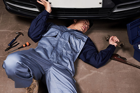 穿着工作服维修汽车的成年男子图片