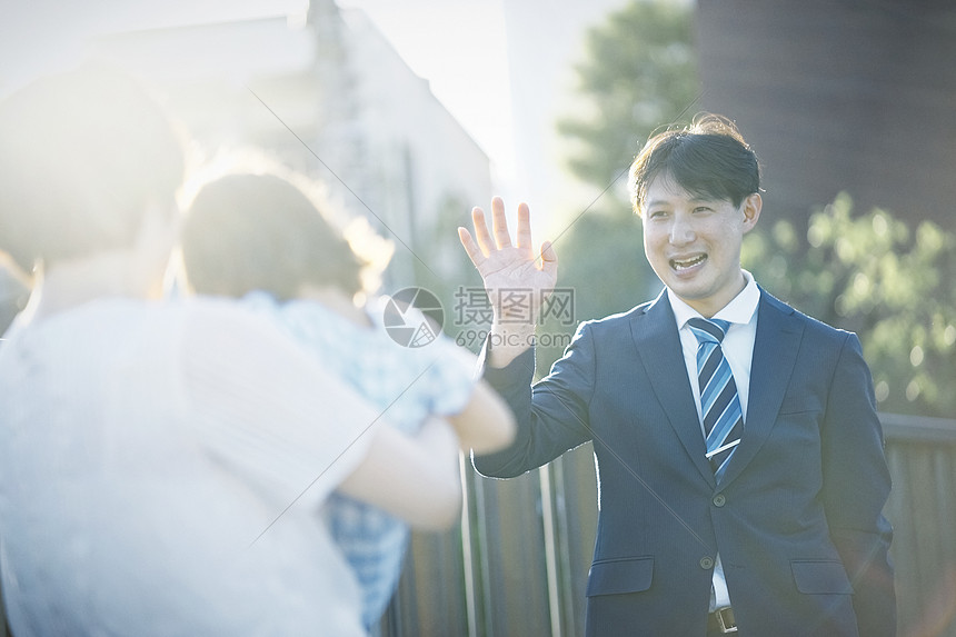 穿着西装开心挥手的成年男子图片