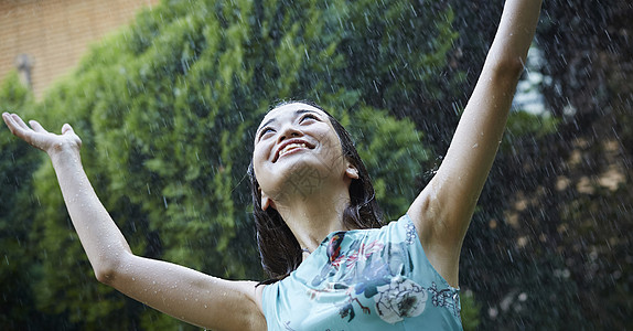 在雨中张开双臂的年轻女孩图片