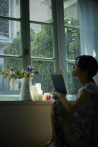 下雨天在窗边放松的女孩高清图片