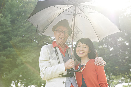 阳光明媚的打伞的老年情侣图片