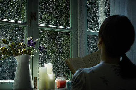 雨夜看向窗外放松的女性背影图片