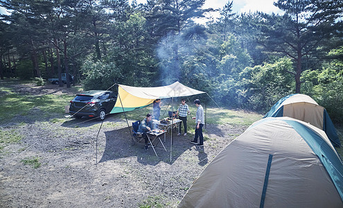 假期户外野营地烧烤的家庭图片