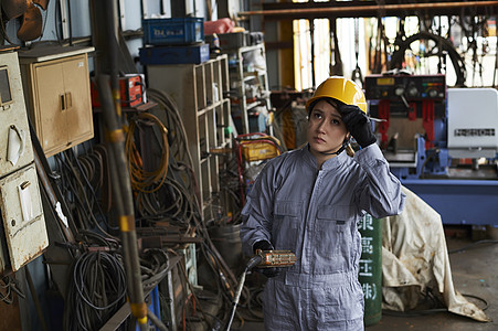 工厂内穿着工作服和安全帽的女性工人图片