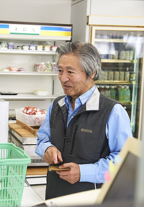 老年顾客在便利店的收银台结账图片