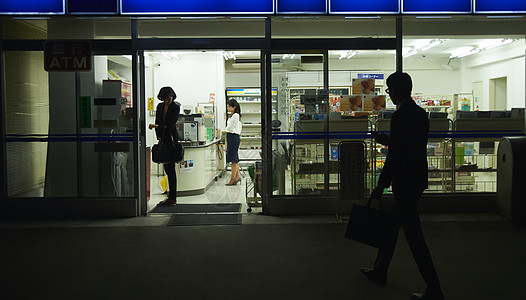 日本灯会夜晚在便利店购物的人们背景