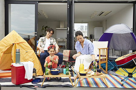 假日户外阳台上露营野餐的一家三口图片