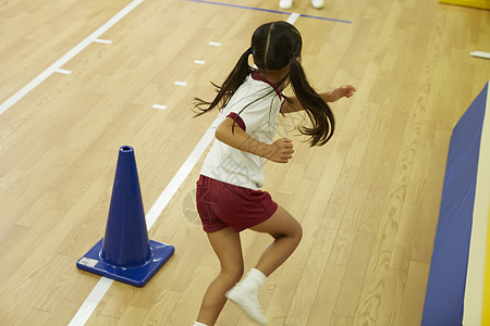 室内体育馆奔跑的小女孩背影图片