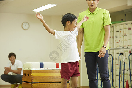 体操课堂训练跳箱的小男孩图片