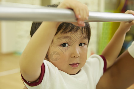 孩子量身高单杠上练习的小男孩背景