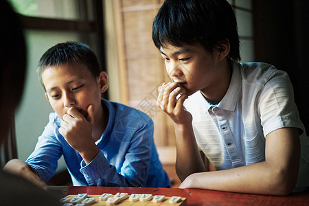 看着棋盘思考的孩子们图片