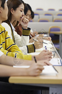 黄色调大学生教室认真听课做笔记背景