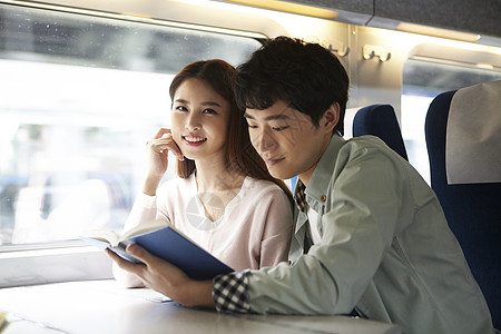 火车看书火车上阅读书籍的情侣背景
