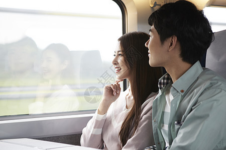 坐在火车上开心的年轻女性图片