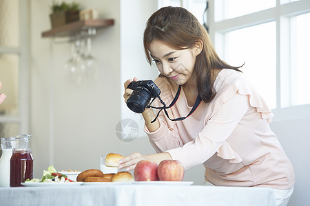 拿着相机拍食物照片的女性图片