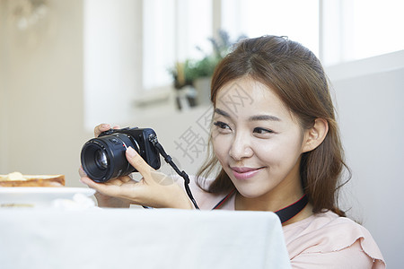 年轻女孩手拿相机记录生活图片