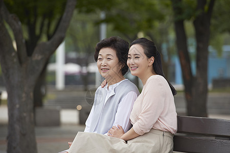 坐在公园椅子上的母女图片