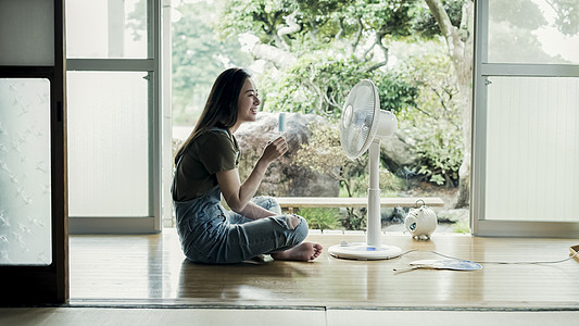 在家吹风扇吃冰棒的妇女背景图片