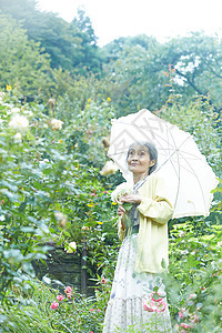 户外庭院打着遮阳伞的女性图片