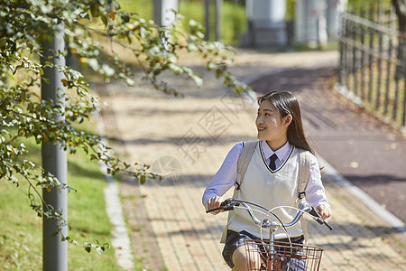 校园里的高中生骑单车背景图片