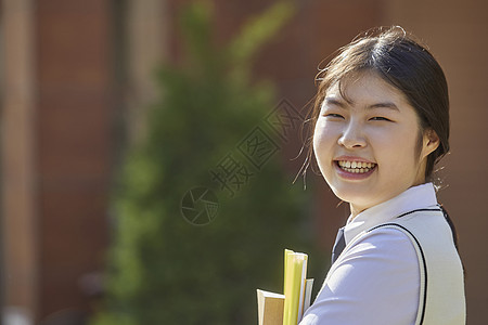 高中生手抱书本形象背景图片