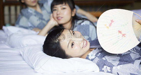 卧姿轻松微笑放松在旅馆的妇女图片