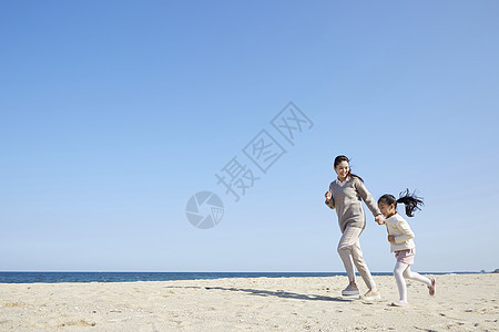 母女在沙滩上奔跑图片