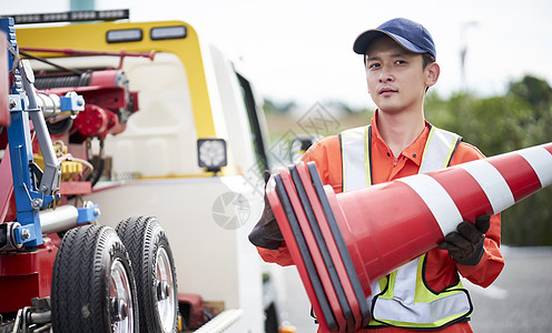 搬运桶锥放置路障的道路救援服务人员图片