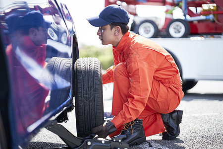 道路救援服务人员拆卸更换轮胎高清图片